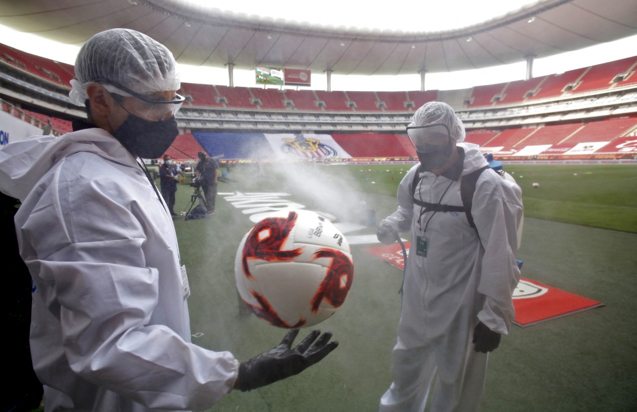 Bola é desinfetada antes de jogo do Campeonato Mexicano, em julho de 2020. Pandemia de Covid-19 fez o futebol mundial se adaptar aos protocolos sanitários - Ulises Ruiz / AFP