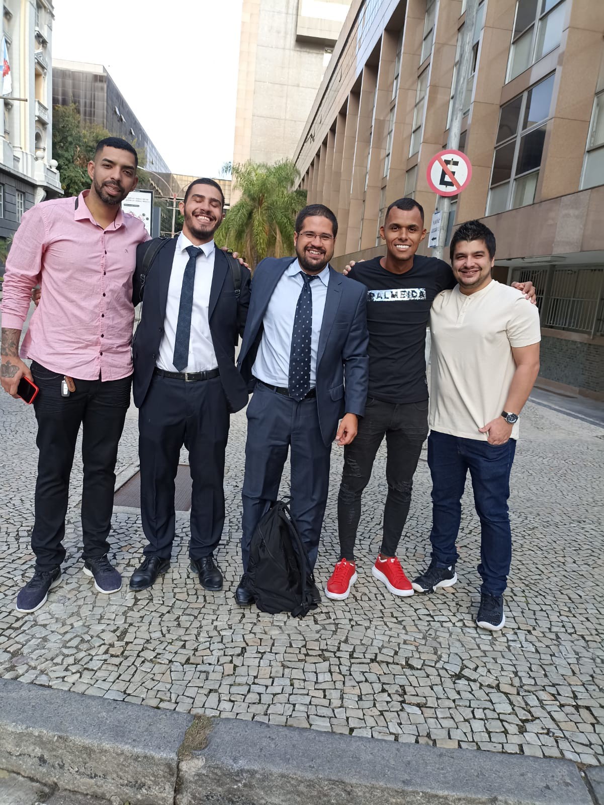 Vinícius (à esquerda), Max e João (à direita) ao lado dos advogados na saída da audiência que decidiu pela inocência dos amigos - Arquivo Pessoal