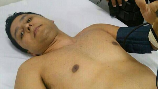 O cabo Vinícius Salles de Oliveira sendo atendido após ter o braço ferido em ataque à UPP