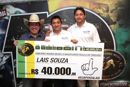 O pai e o irmão de Lais, Antônio Luís Souza e Matheus da Silva Souza, recebem o cheque de Matheus Calil, um dos organizadores do Ribeirão Rodeo Music