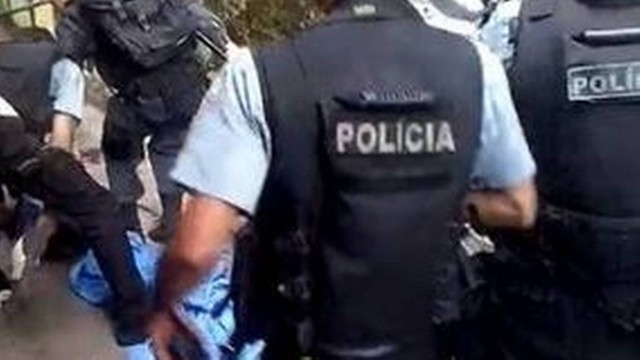 Policiais junto a homem baleado em tiroteio na Rocinha