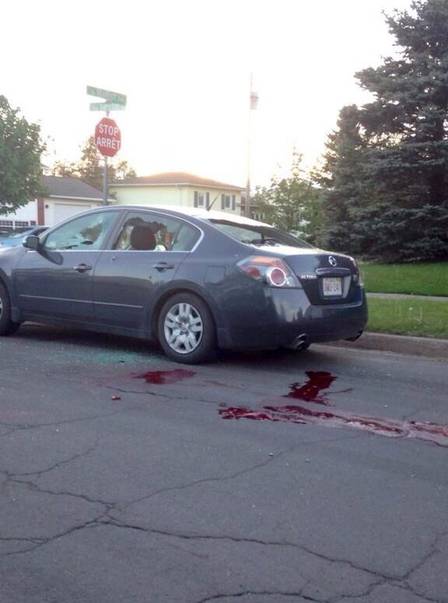 A foto mostra um suposto carro de polícia não identificado com os vidros estilhaçados pelos tiros e marcas de sangue no chão