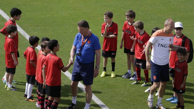 Robben sorri e dá atenção para os garotos do Flamengo, enquanto o técnico Van Gaal cumprimenta os meninos