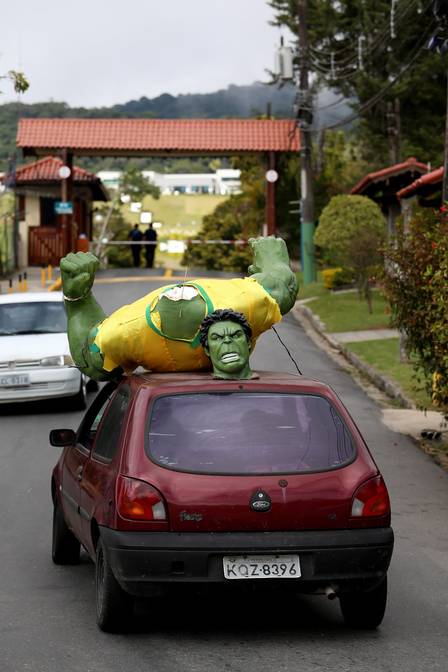 Carro leva a estátua de Hulk para dentro da Granja Comary