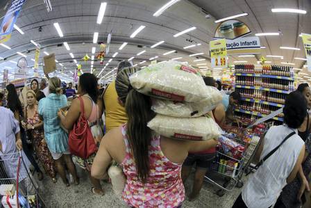 Cliente carrega arroz no Aniversário do Supermercados Guanabana
