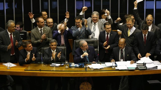 O presidente da Câmara dos Deputados, Eduardo Cunha (PMDB-RJ), presidindo a sessão durante a votação e alguns deputados comemorando a votação no plenário