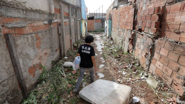 Moradora da Vila Autódromo há 21 anos, Maria da Penha atravessa uma ruela surgida após a demolição de algumas casas