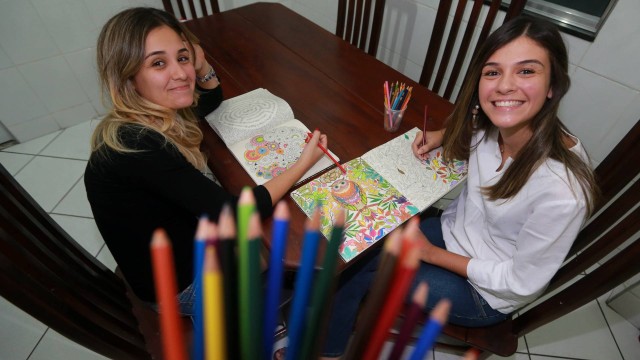 As irmãs Juliana (de preto) e Maria Clara gostam de colorir juntas