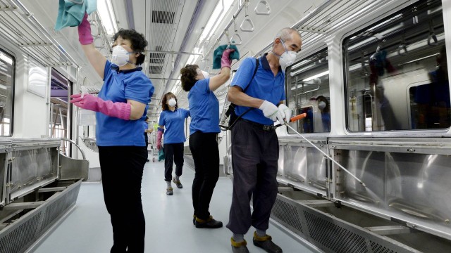 Funcionários em transporte público desinfectam o ambiente