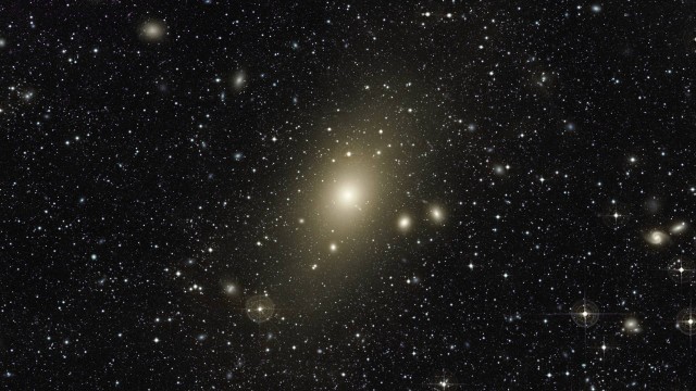 O enorme halo em torno da galáxia elíptica gigante Messier 87, a maior no Aglomerado de Virgem: astrônomos encontraram evidências de que ela absorveu um galáxia espiral de tamanho médio no último bilhão de anos