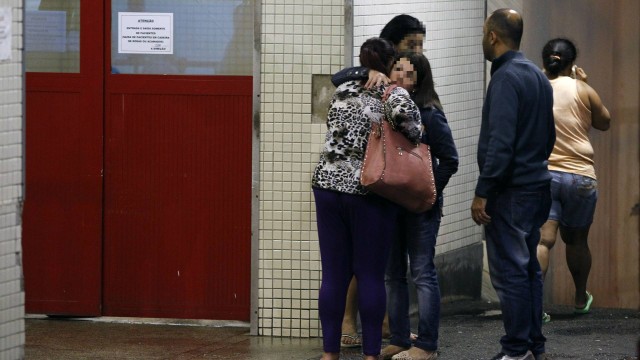 Parentes dos feridos se abraçam na porta do hospital