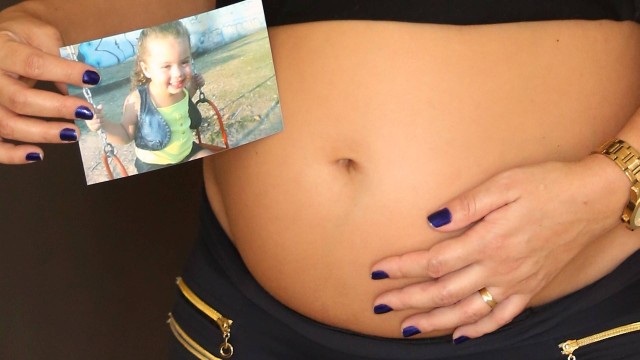 A barriga de Milene, grávida de seis meses de Lorenzo, e a foto de Larissa, morta em janeiro.