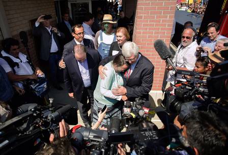 Kim Davis abraçada em seu advogado, Matt Staver, e o candidato a presidente dos EUA, Mike Huckabee.