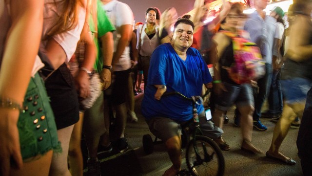 Com pernas e braços atrofiados, Daniel Martins se equilibra em uma bicicleta adaptada durante o show dos Paralamas do Sucesso