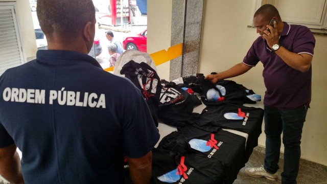 Fiscais da Seop com as camisas falsificadas que foram apreendidas em Copacabana