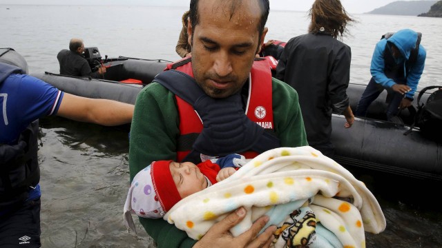 Refugiado síria carrega bebê após atravessar o Mar Egeu e chegar à Grécia a partir da Turquia