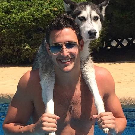 Mike posa com seu cachorro em uma piscina