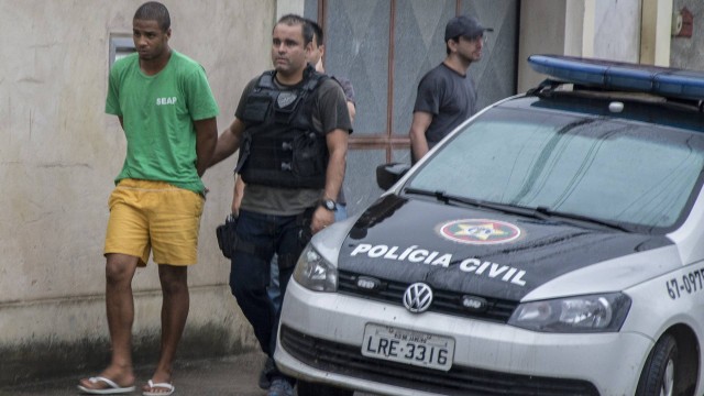 O suspeito Paulo Sérgio Souza ajuda a fazer a reconstituição do assassinato do policial militar Alyson Leonardo, em Meriti