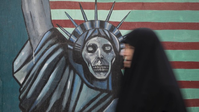 Iraniana passa por mural antiamericano em rua no Teerã