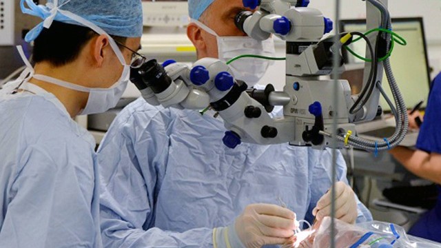 O professor Robert MacLaren realiza cirurgia para inserção de vírus no olho de um paciente
