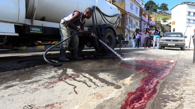 Morador lava o local onde o sargento do BOPE foi baleado , na Rua Barão de Gamboa.