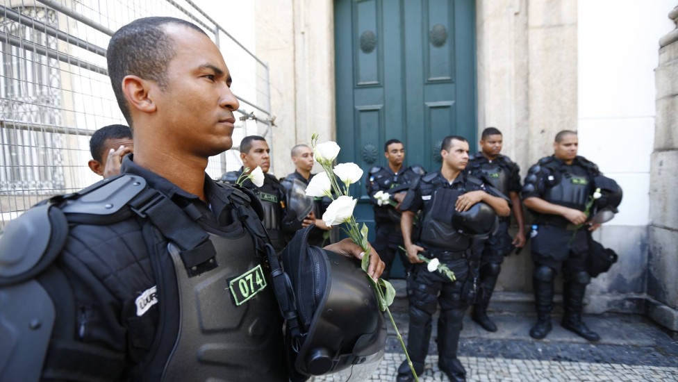 Policial recebe flor de manifestante em frente à Alerj