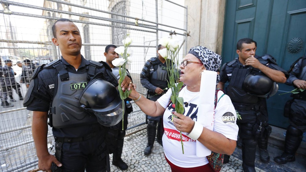 Manifestante entrega flor para policial