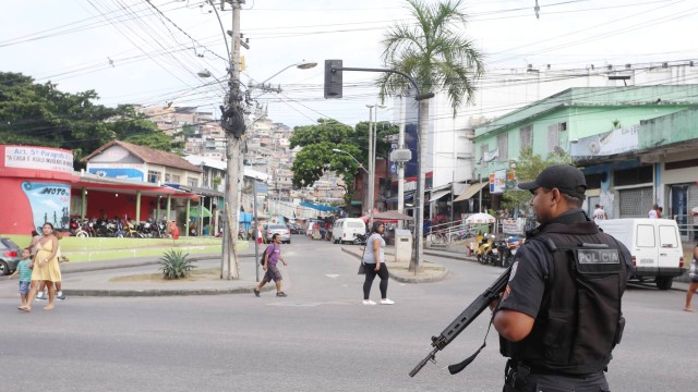 Policial patrulha o entorno do Complexo do Alemão, na Zona Norte do Rio.