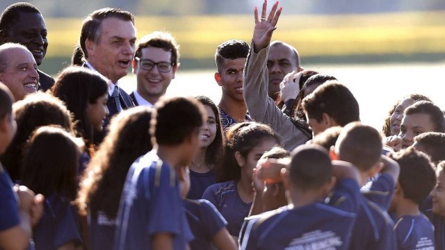 Jair Bolsonaro na cerimônia de hasteamento da bandeira com alunos do 5º ano da escola Bela Vista, do Novo Gama (GO)