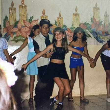 Nayandra, quando criança, dançando Sandy e Junior