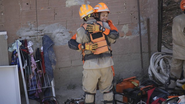 Os bombeiros comemoram, após o resgate de mãe e filho