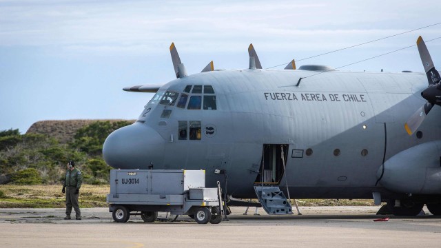 Homem ao lado de avião da Força Aérea chilena usado nas buscas à aeronave ddesaparecida C-130 Hércules
