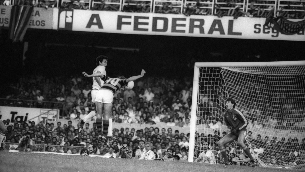Flamengo 2 x 0 Santos. Zico ganha a disputa de bola com o zagueiro e cabeceia para vencer o assustado Marola no primeiro gol do Fla