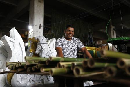 O carnavalesco Marcus Paulo usa varas de bambu para cobrir um dos carros da Acadêmicos da Rocinha