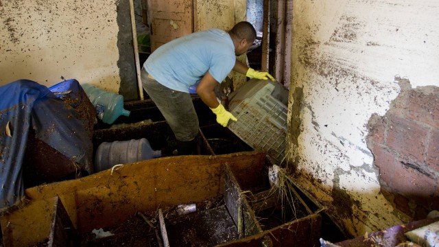 No Barata, em Realengo, moradores tentam limpar suas casas nesta terça-feira após a chuva no Rio
