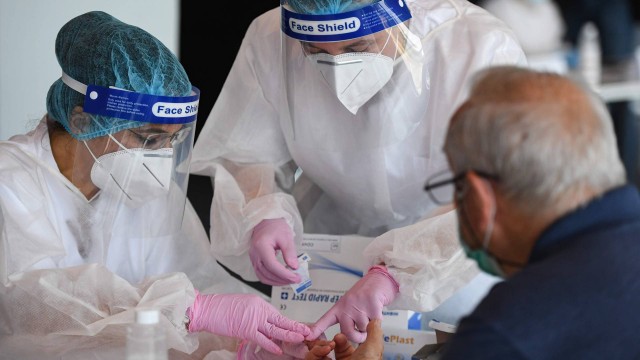 Um homem é testado para o novo coronavírus no Estádio Nacional de Bucareste, na Romênia