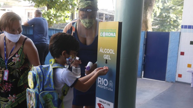 Aluno faz a higienização ao chegar na Escola municipal Suíça, na Penha, na Zona Norte do Rio