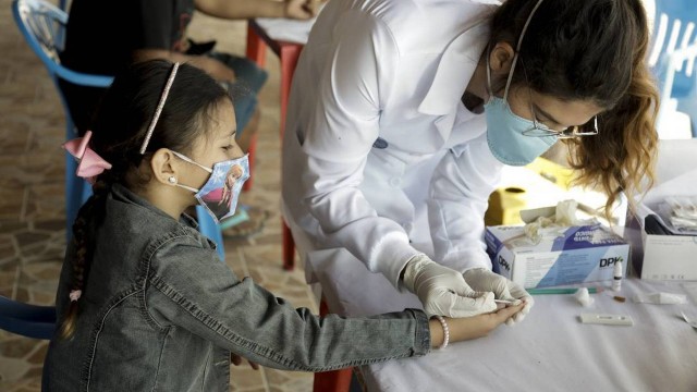 Criança faz exame de sangue para detectar Covid na ilha de Paquetá, no RJ, em foto de junho de 2021
