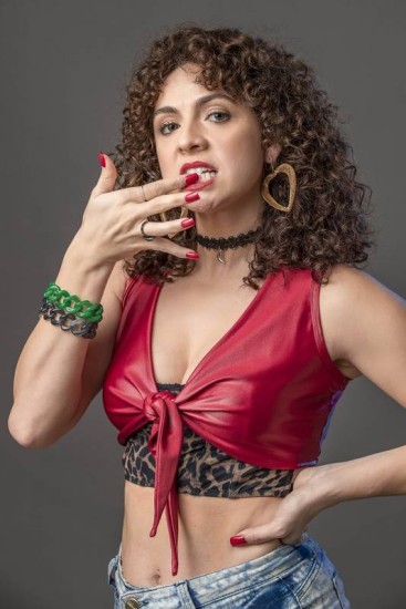 Renata Gaspar caracterizada como Stephany: peruca, unhas compridas e roupa decotada