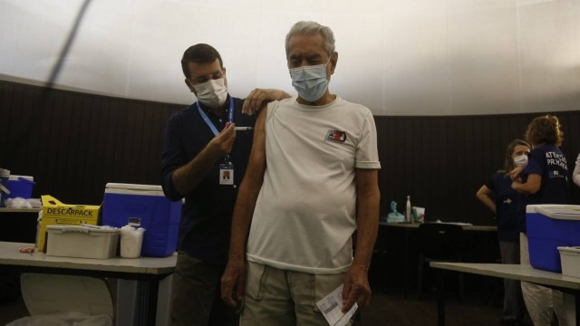 O secretário municipal de Saúde, Daniel Soranz, aplica a quarta dose contra a Covid-19 em Aroldo Corrêa da Silva, 85 anos