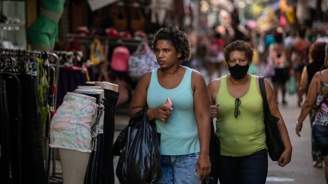 Pessoas caminham pelo Saara após liberação das máscaras no Rio. Fotografia: Brenno Carvalho / Agência O Globo
