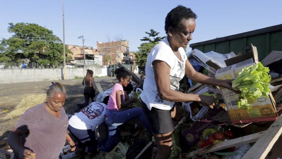 Denise da Silva busca comida nos restos deixados no lixo da Ceasa