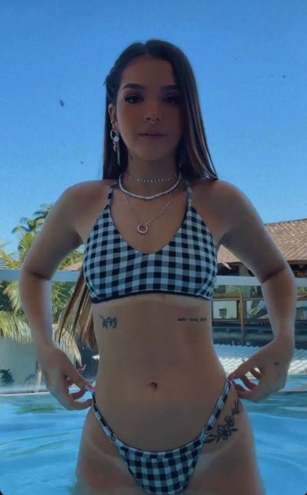 Mel Maia curte piscina com biquíni xadrez e mostra tatuagem na virilha