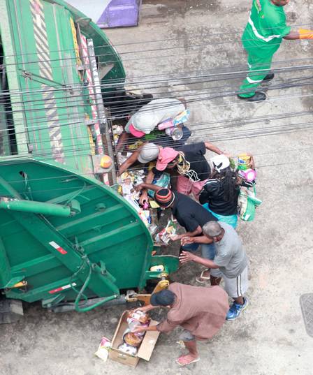 Pessoas recolhem alimentos do lixo descartados por supermercado no RJ