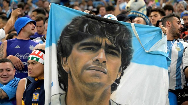 Torcedor argentino seguran bandeira com o rosto de Diego Maradona, na Copa do Mundo do Catar