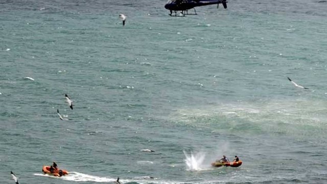 Policais patrulham as águas da praia de Muriwai em busca do tubarão