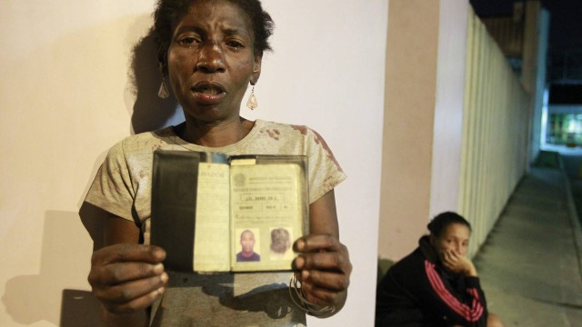 Maria Lúcia Benedito, de 48 anos, mostra a carteira de trabalho do filho