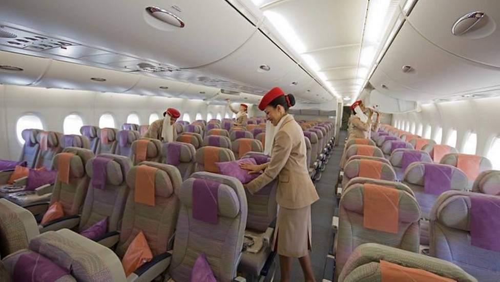 Aeromoças preparam as poltronas da classe ecônimca a no A380 da Emirates